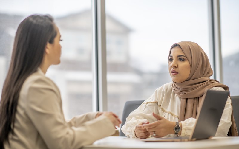 Zwei Frauen am Tisch im Gespräch